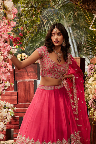 Hot pink raw silk embroidered lehenga with embroidered blouse paired with an organza dupatta