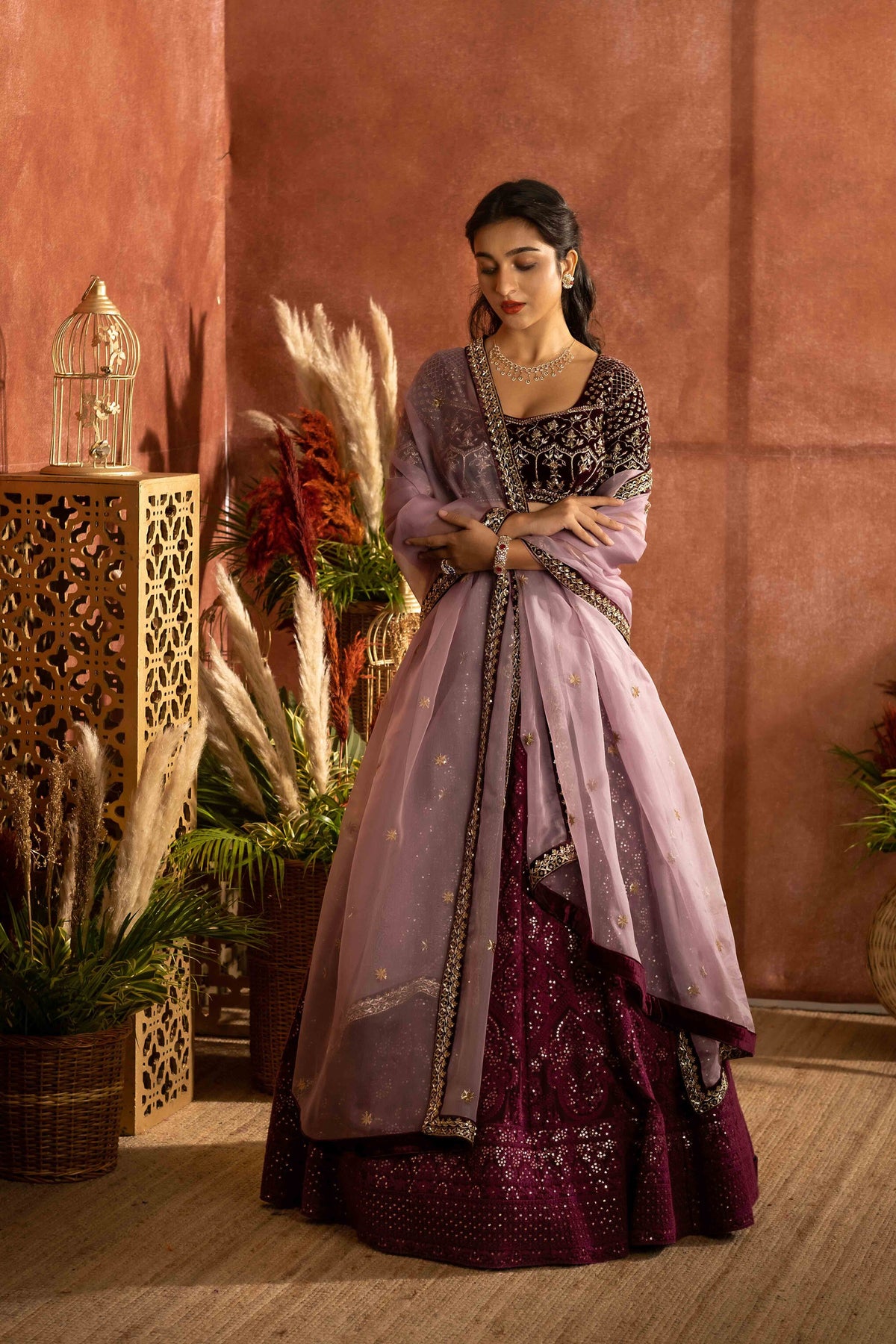 Wine chikankari lehenga with velvet embroidered blouse paired with an organza dupatta