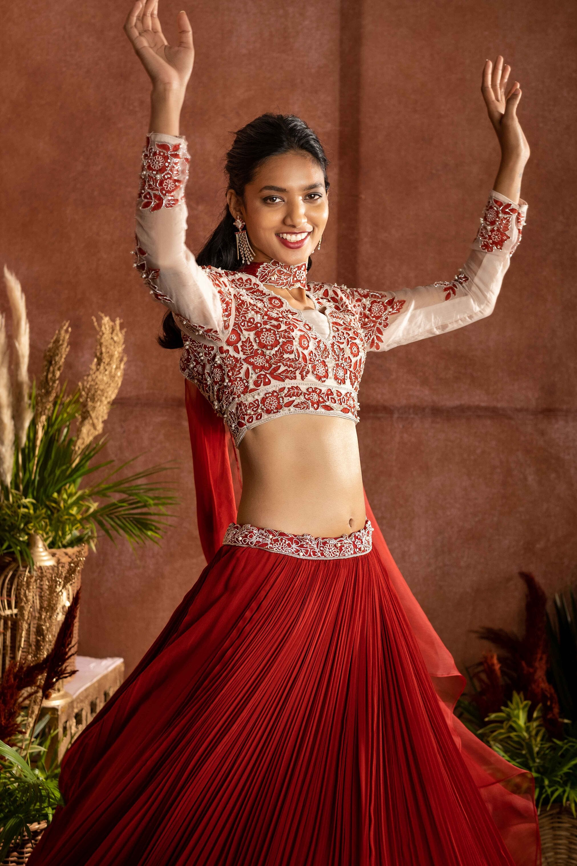 Rust georgette pleated lehenga with organza embroidered blouse paired with choker dupatta