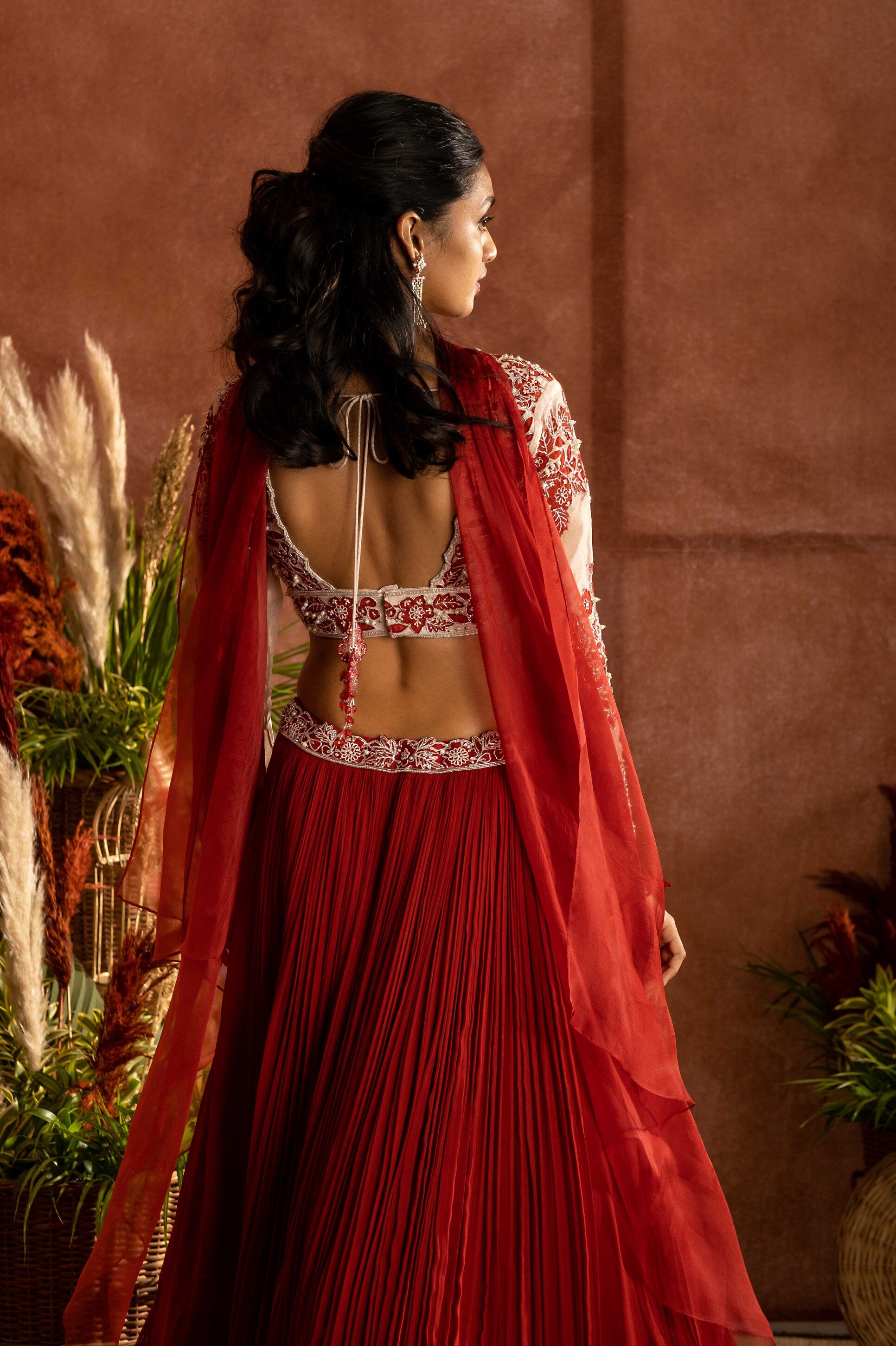 Rust georgette pleated lehenga with organza embroidered blouse paired with choker dupatta