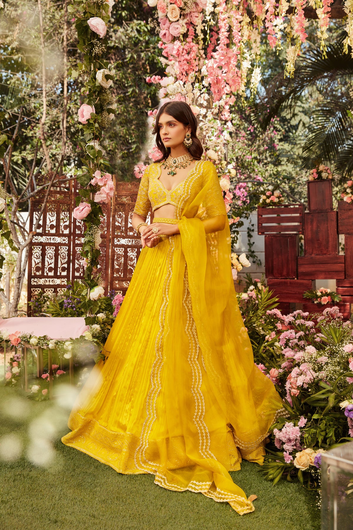 Yellow pleated lehenga with raw silk embroidered blouse paired with an organza embroidered dupatta