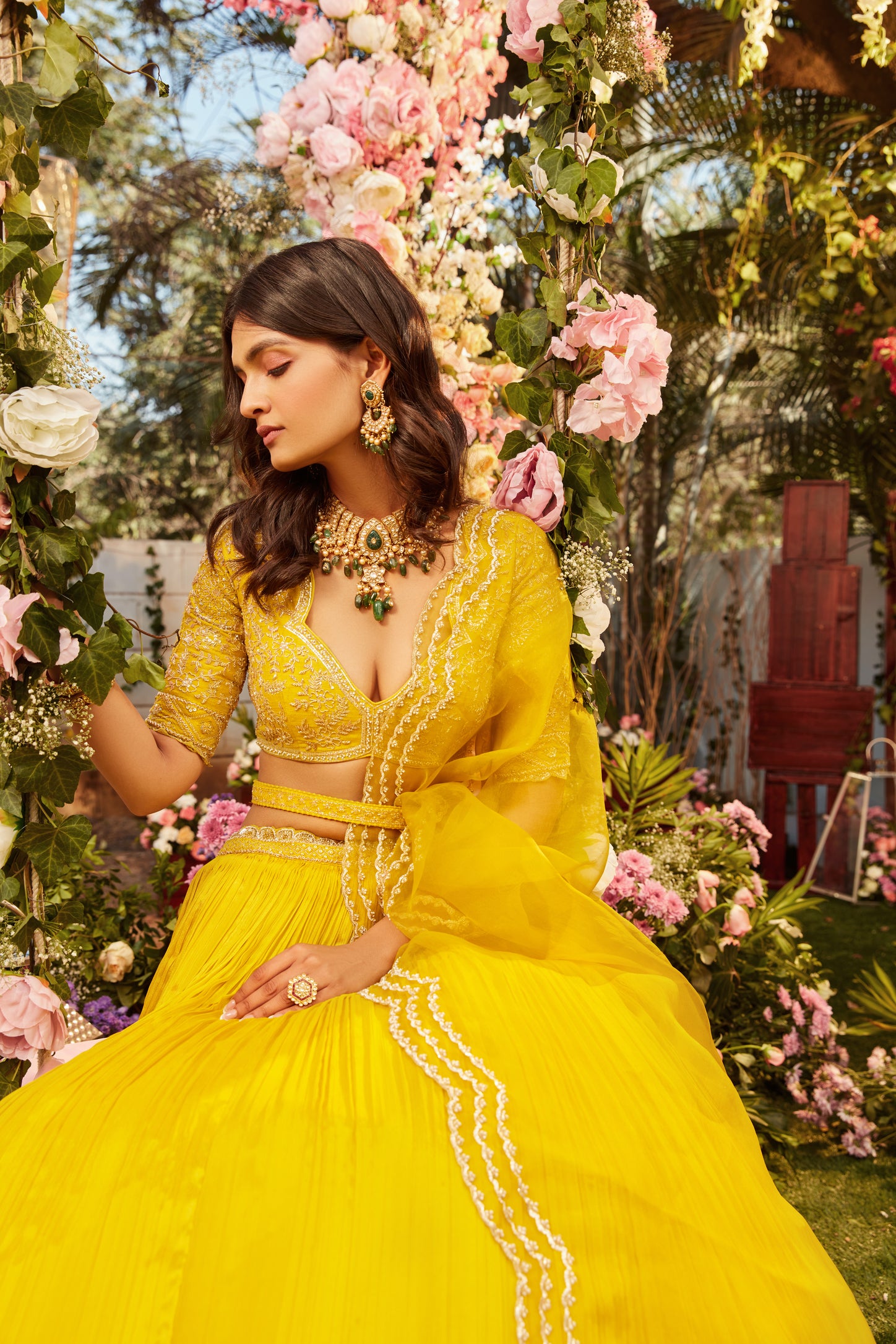 Yellow pleated lehenga with raw silk embroidered blouse paired with an organza embroidered dupatta