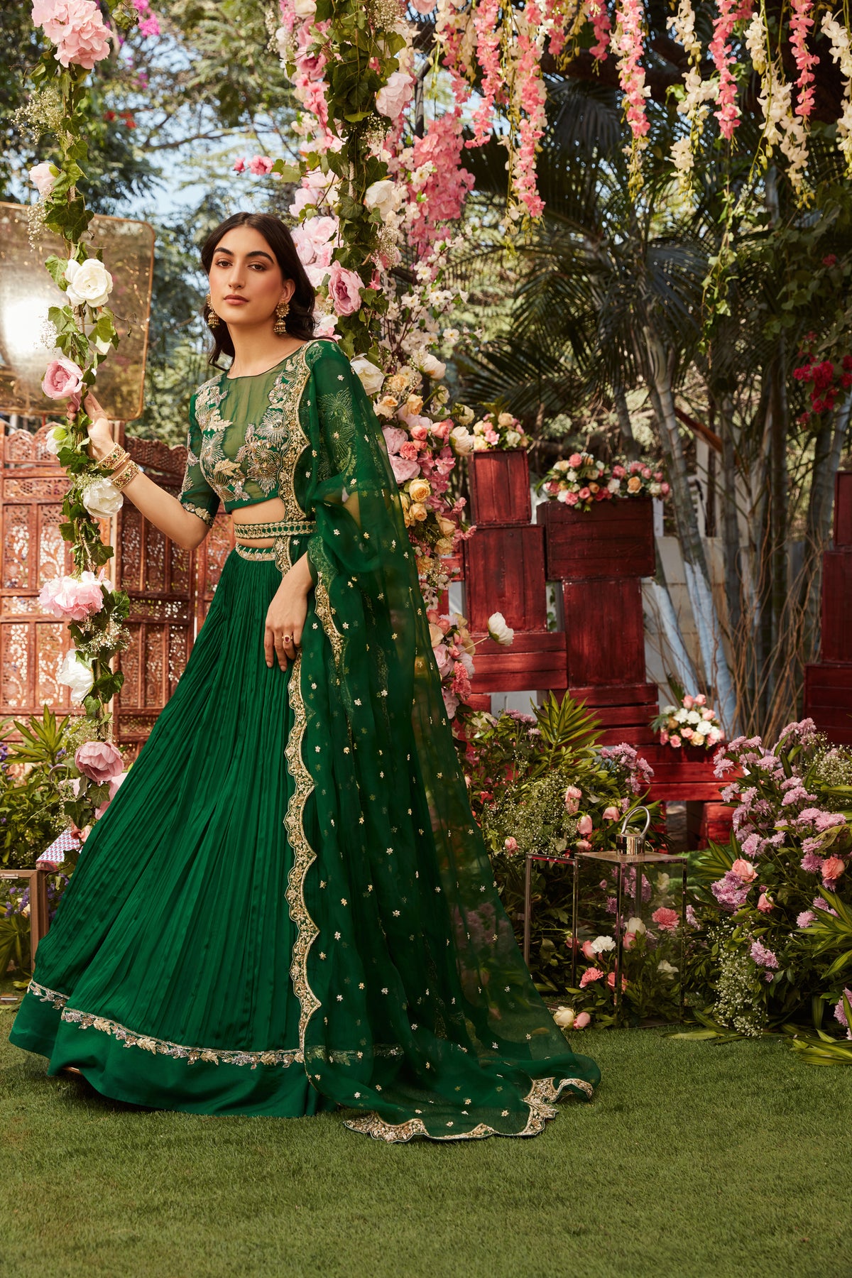 Forest green pleated lehenga with an organza embroidered blouse paired with an organza embroidered dupatta
