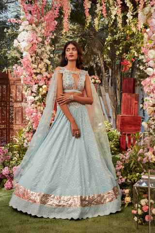 Ice blue chikankari lehenga with raw silk embroidered paired with an embroidered organza cape