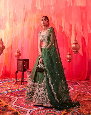 Green raw silk embroidered lehenga with embroidered blouse paired with an embroidered dupatta